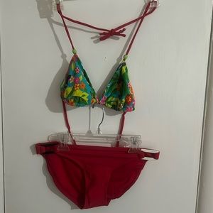 2 piece medium Hawaiian hula girl, floral plant, print top and red bottom.